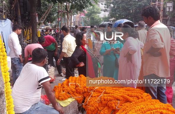 Sellers sell flowers at the roadside as people buy marigold and lotus flowers to decorate their houses during Diwali, the festival of Lights...