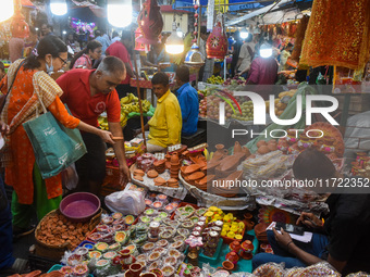 People buy clay lamps at a market ahead of the Diwali festival in Kolkata, India, on October 30, 2024. (