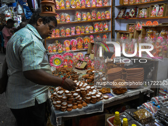 People buy clay lamps at a market ahead of the Diwali festival in Kolkata, India, on October 30, 2024. (