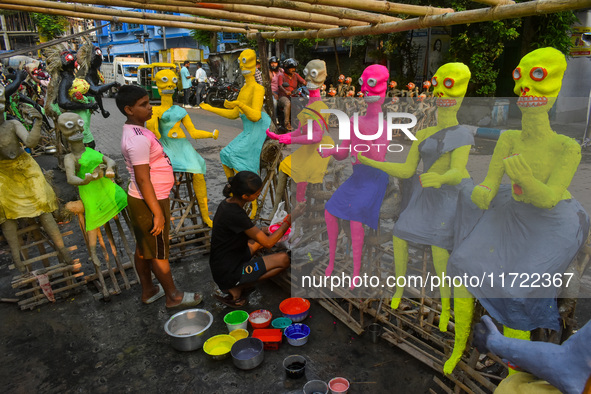 A girl paints figurines of demons that are for sale ahead of Bhoot Chaturdashi, or the Indian Halloween festival, in Kolkata, India, on Octo...