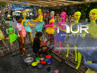 A girl paints figurines of demons that are for sale ahead of Bhoot Chaturdashi, or the Indian Halloween festival, in Kolkata, India, on Octo...