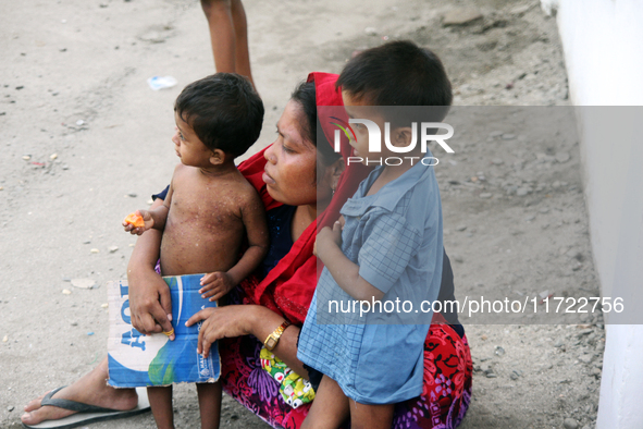 Two Rohingya refugee children and their mother are in a temporary shelter for Rohingya refugees at the Pantai Labu District Office in Deli S...