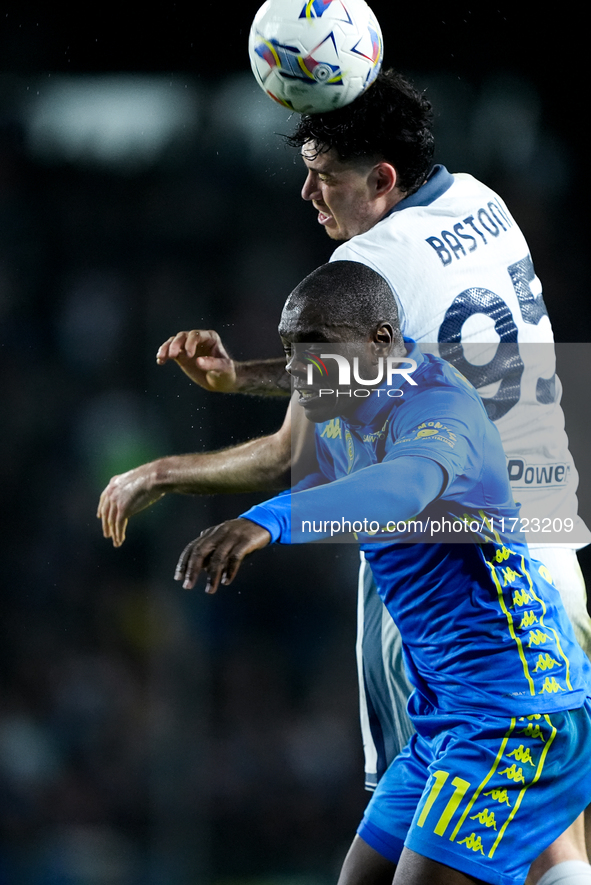 Alessandro Bastoni of FC Internazionale and Emmanuel Gyasi of Empoli FC jump for the ball during the Serie A Enilive match between Empoli FC...