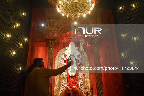 People take selfies on their mobile phones inside a pandal, or temporary platform, of the Kali Puja festival in Kolkata, India, on October 3...