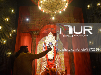 People take selfies on their mobile phones inside a pandal, or temporary platform, of the Kali Puja festival in Kolkata, India, on October 3...