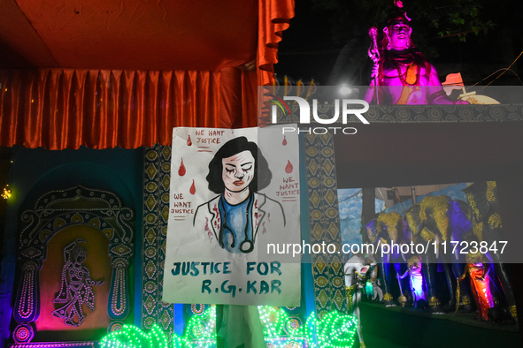 A poster about the rape and murder case of a doctor from R G Kar Medical College and Hospital is seen at a pandal during the Kali Puja festi...