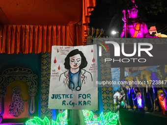 A poster about the rape and murder case of a doctor from R G Kar Medical College and Hospital is seen at a pandal during the Kali Puja festi...