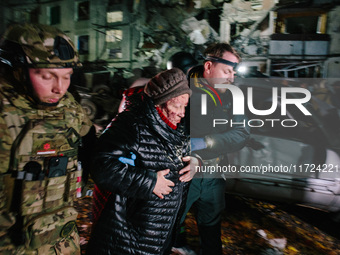 Rescuers help a woman who suffers a blow, following a Russian airstrike in Kharkiv, Ukraine, on October 30, 2024, a bomb struck a residentia...