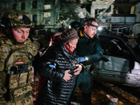 Rescuers help a woman who suffers a blow, following a Russian airstrike in Kharkiv, Ukraine, on October 30, 2024, a bomb struck a residentia...