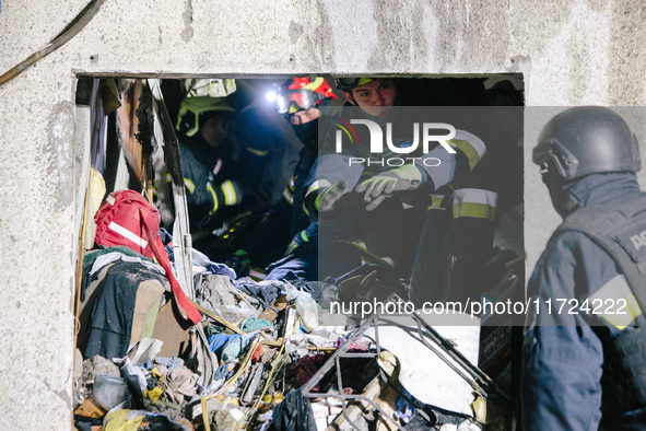 Rescuers work at the site of debris removal, following a Russian airstrike in Kharkiv, Ukraine, on October 30, 2024, a bomb struck a residen...