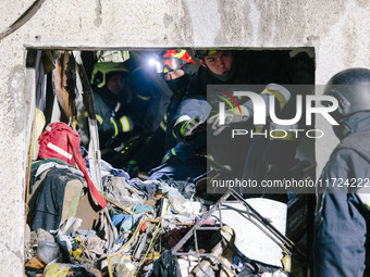 Rescuers work at the site of debris removal, following a Russian airstrike in Kharkiv, Ukraine, on October 30, 2024, a bomb struck a residen...