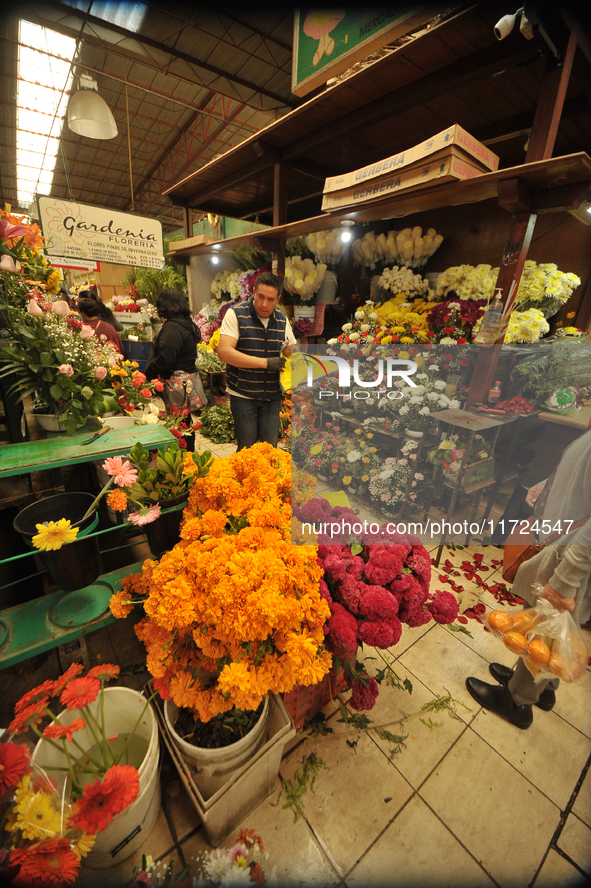 A vendor offers cempasuchil flowers inside a market in the municipality of San Juan del Rio. Local market vendors offer items to decorate th...