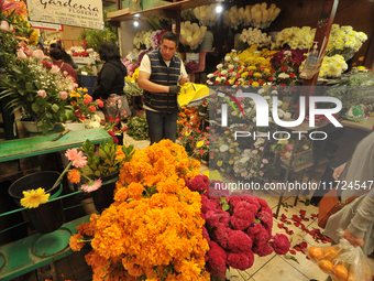 A vendor offers cempasuchil flowers inside a market in the municipality of San Juan del Rio. Local market vendors offer items to decorate th...