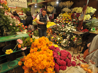 A vendor offers cempasuchil flowers inside a market in the municipality of San Juan del Rio. Local market vendors offer items to decorate th...