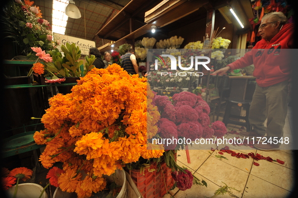 A vendor offers cempasuchil flowers inside a market in the municipality of San Juan del Rio. Local market vendors offer items to decorate th...