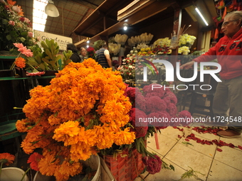 A vendor offers cempasuchil flowers inside a market in the municipality of San Juan del Rio. Local market vendors offer items to decorate th...