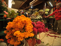 A vendor offers cempasuchil flowers inside a market in the municipality of San Juan del Rio. Local market vendors offer items to decorate th...