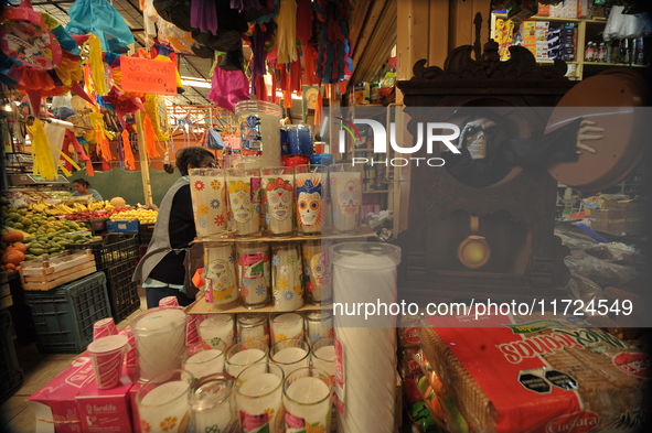 A vendor offers candles inside a market in the municipality of San Juan del Rio. Local market vendors offer items to decorate the offerings,...