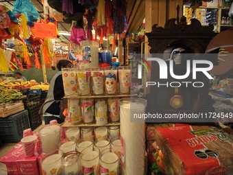 A vendor offers candles inside a market in the municipality of San Juan del Rio. Local market vendors offer items to decorate the offerings,...