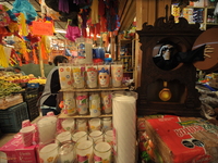 A vendor offers candles inside a market in the municipality of San Juan del Rio. Local market vendors offer items to decorate the offerings,...