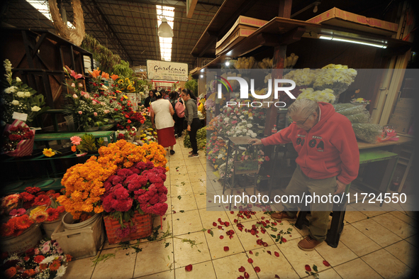 A vendor offers cempasuchil flowers inside a market in the municipality of San Juan del Rio. Local market vendors offer items to decorate th...