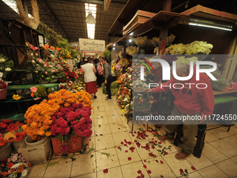 A vendor offers cempasuchil flowers inside a market in the municipality of San Juan del Rio. Local market vendors offer items to decorate th...