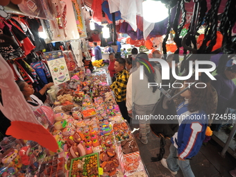 A vendor offers sugar skulls known as calaverita de azucar inside a market in the municipality of San Juan del Rio. Local market vendors off...