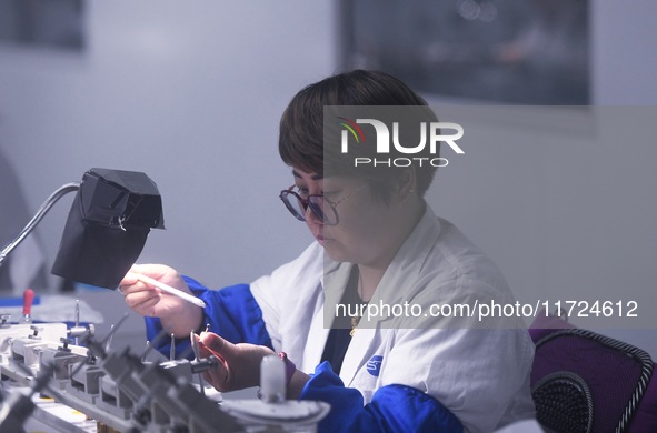 An employee processes medical endoscope lenses at the production workshop of Hangzhou HAoke Optoelectronic Instrument Co., LTD., located in...