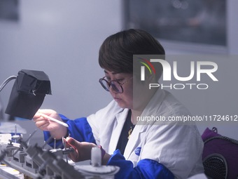 An employee processes medical endoscope lenses at the production workshop of Hangzhou HAoke Optoelectronic Instrument Co., LTD., located in...