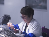 An employee processes medical endoscope lenses at the production workshop of Hangzhou HAoke Optoelectronic Instrument Co., LTD., located in...