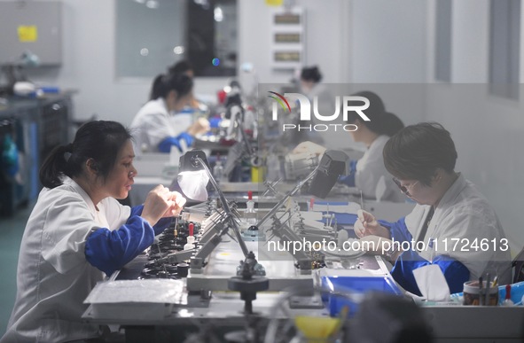 Employees process medical endoscope lenses at the production workshop of Hangzhou HAoke Optoelectronic Instrument Co., LTD., located in Suoq...