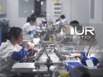 Employees process medical endoscope lenses at the production workshop of Hangzhou HAoke Optoelectronic Instrument Co., LTD., located in Suoq...