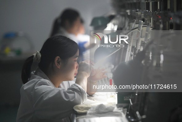 Employees process medical endoscope lenses at the production workshop of Hangzhou HAoke Optoelectronic Instrument Co., LTD., located in Suoq...