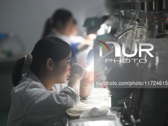 Employees process medical endoscope lenses at the production workshop of Hangzhou HAoke Optoelectronic Instrument Co., LTD., located in Suoq...