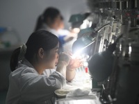 Employees process medical endoscope lenses at the production workshop of Hangzhou HAoke Optoelectronic Instrument Co., LTD., located in Suoq...