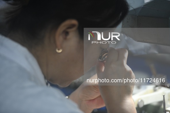 An employee processes medical endoscope lenses at the production workshop of Hangzhou HAoke Optoelectronic Instrument Co., LTD., located in...