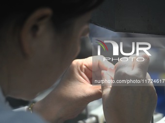 An employee processes medical endoscope lenses at the production workshop of Hangzhou HAoke Optoelectronic Instrument Co., LTD., located in...