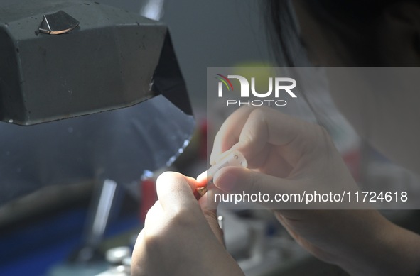 An employee processes medical endoscope lenses at the production workshop of Hangzhou HAoke Optoelectronic Instrument Co., LTD., located in...