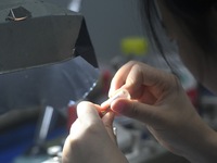 An employee processes medical endoscope lenses at the production workshop of Hangzhou HAoke Optoelectronic Instrument Co., LTD., located in...