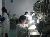 Employees process medical endoscope lenses at the production workshop of Hangzhou HAoke Optoelectronic Instrument Co., LTD., located in Suoq...