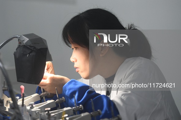 An employee processes medical endoscope lenses at the production workshop of Hangzhou HAoke Optoelectronic Instrument Co., LTD., located in...