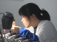 An employee processes medical endoscope lenses at the production workshop of Hangzhou HAoke Optoelectronic Instrument Co., LTD., located in...