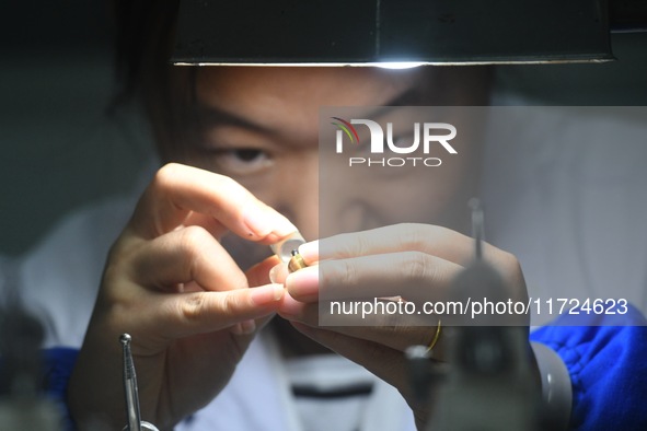 An employee processes medical endoscope lenses at the production workshop of Hangzhou HAoke Optoelectronic Instrument Co., LTD., located in...