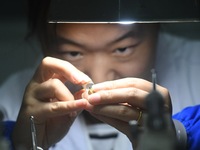 An employee processes medical endoscope lenses at the production workshop of Hangzhou HAoke Optoelectronic Instrument Co., LTD., located in...