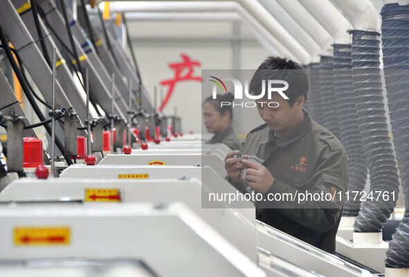 A worker checks product quality at a digital intelligent production workshop at a hardware manufacturing company in Handan, China, on Octobe...