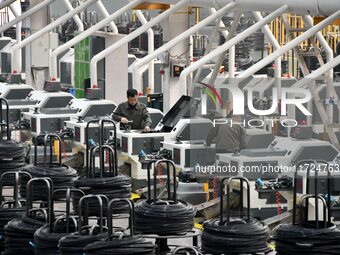 A worker checks equipment operation at a digital intelligent production workshop at a hardware manufacturing company in Handan, China, on Oc...