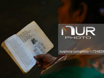 A Hindu devotee reads the Hindu religious book at the Sri Ponnambala Vaneswarar Hindu temple in Colombo, Sri Lanka, on October 31, 2024. Diw...