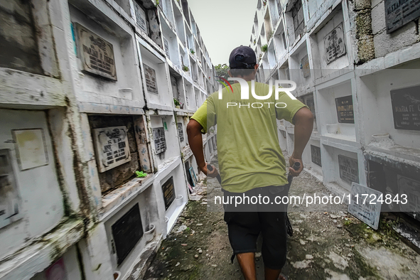 Erwin, in green, exhumes the remains buried inside the public cemetery in Antipolo City, Philippines, on October 31, 2024. A sack of human r...