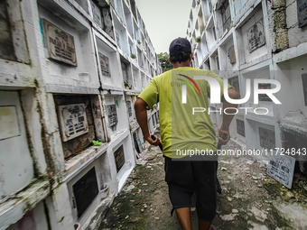 Erwin, in green, exhumes the remains buried inside the public cemetery in Antipolo City, Philippines, on October 31, 2024. A sack of human r...