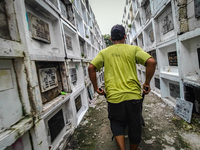 Erwin, in green, exhumes the remains buried inside the public cemetery in Antipolo City, Philippines, on October 31, 2024. A sack of human r...